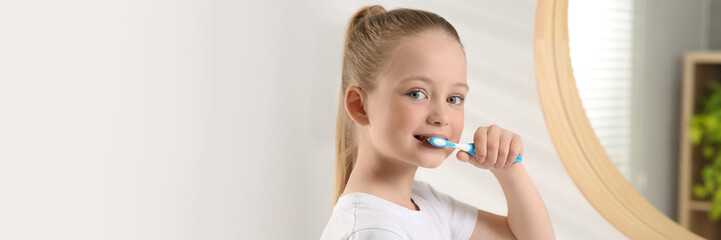 Cute little girl brushing her teeth with plastic toothbrush in bathroom. Banner design with space for text