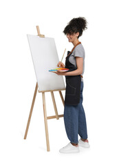 Young woman painting on easel with canvas against white background