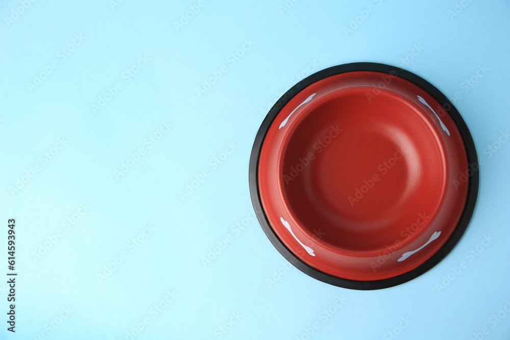 Canvas Prints Empty red feeding bowl on light blue background, top view. Space for text