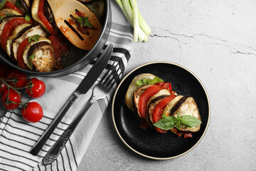 Delicious ratatouille served with basil on light grey table, flat lay. Space for text