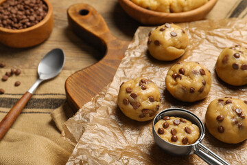 Uncooked chocolate chip cookies on wooden table, closeup