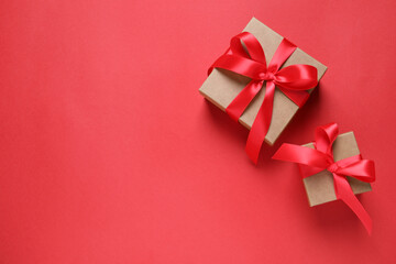 Beautiful gift boxes on red background, flat lay. Space for text