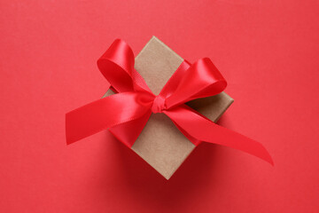 Beautiful gift box with bow on red background, top view