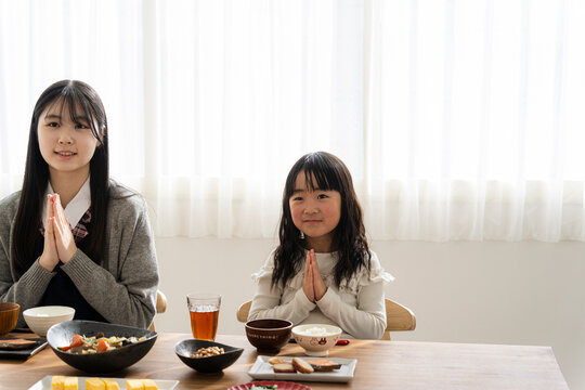 食事のあいさつをする日本人姉妹
