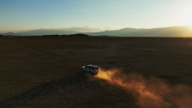 Off-road Vehicle Driving Through The Dusty Dry Lagoon In Sunset In Sayula, Jalisco, Mexico. - aerial