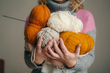 Woman holding in her hands skeins of knitting yarn. Yarn for knitting toys, children's and adult clothes, interior items. Handmade hobby.
