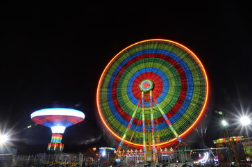 Kedah, Malaysia - July 2017: Funfair's mesmerizing, lit-up ferris wheel spinning joyfully.