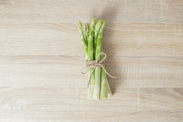 a bunch of asparagus tied with a rope on a wooden background top view