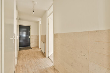 an empty room with wood flooring and white trim on the walls there is a black door in the corner