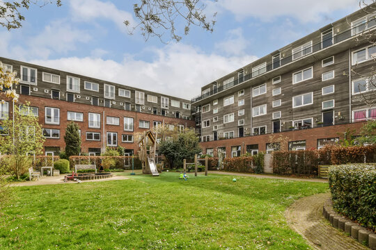 an apartment complex with green grass and trees in the foreground area, london, england - stock image from shutterstocker com