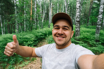 Man smiling and taking a selfie in the forest