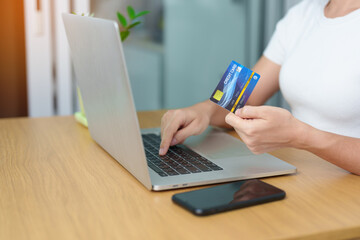 woman hand holding credit card and using laptop with mobile phone for online shopping while making order. Marketplace platform website, technology, ecommerce, digital banking and online payment