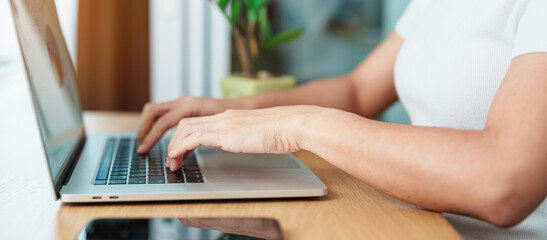 Casual Businesswoman using laptop, freelance woman typing keyboard computer notebook in cafe or modern office. technology, digital online and network concept