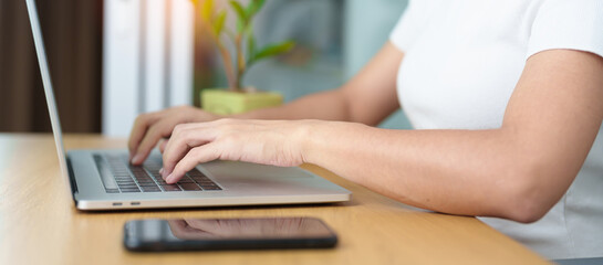 Fototapeta premium Casual Businesswoman using laptop, freelance woman typing keyboard computer notebook in cafe or modern office. technology, digital online and network concept