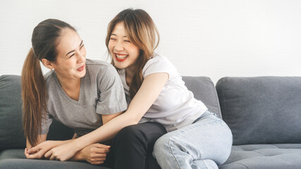 Two young woman couple funny embracing happy romantic moment on sofa at home