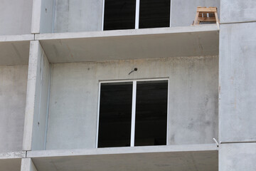 Fragment of an unfinished building. Window opening of a multi-storey block house at the construction stage.