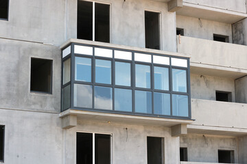 Fototapeta na wymiar One glazed balcony in an unfinished block high-rise building.