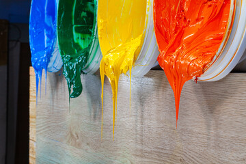 green yellow and orange paints are dripping from white barrel..high quality 4k video.colorful of...