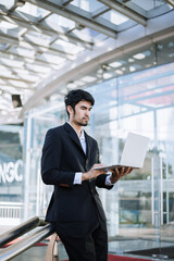 Asian businessman holding laptop.Office worker at business center