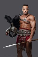Strong and graceful gladiator stands tall in his lightweight armor, wielding a spear and showcasing...