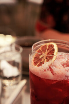 Cropped photo of a glass Raspberry ice tea top with a dehydrated lemon slice                                                            