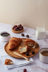 fresh French croissant on a wooden plate with butter