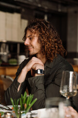 Portrait of cheerful man talking with friends while sitting in restaurant
