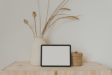 Tablet pad screen with empty free copy space for mock up, clay flowerpot with dried grass, rattan...