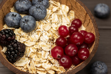Whole oats, blueberries and cranberries in coconut bowls.