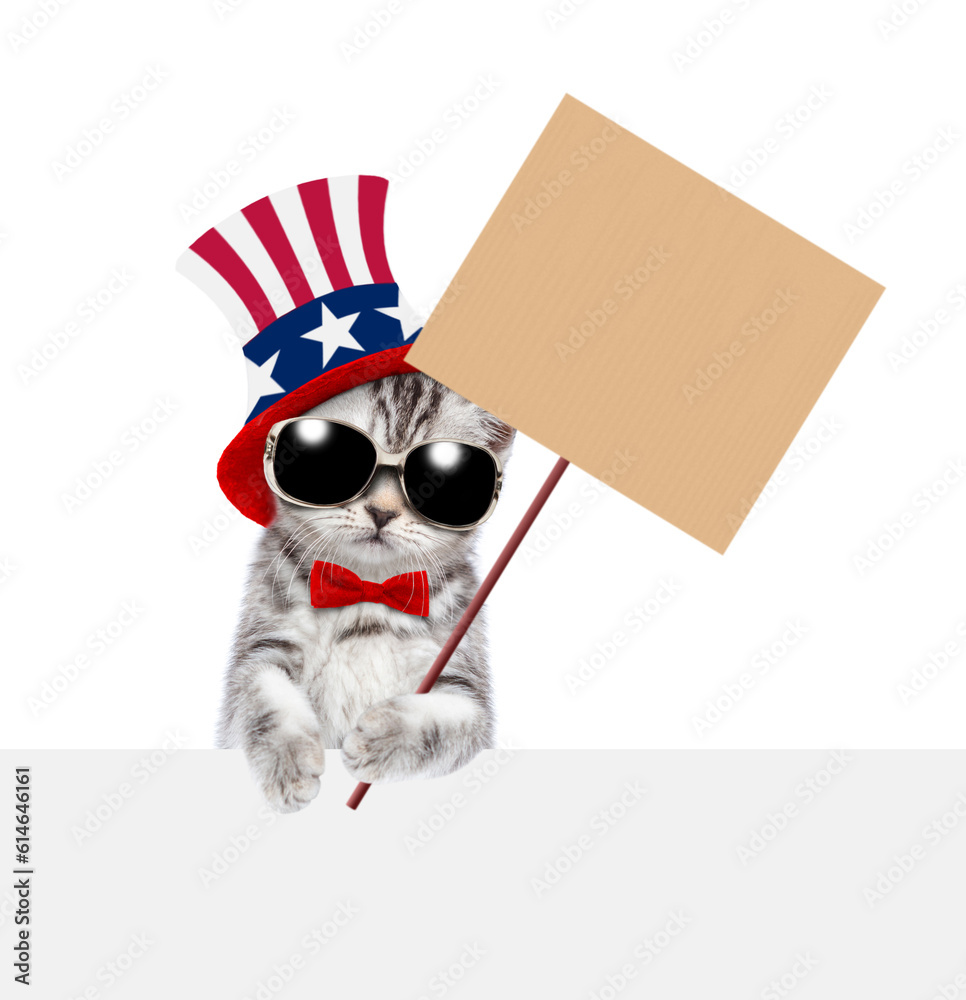Poster cute kitten wearing like uncle sam looks above empty white banner and shows empty placard. isolated 