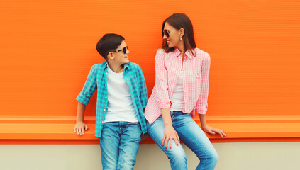 Stylish happy smiling mother with son teenager posing together in sunglasses, checkered shirts,...