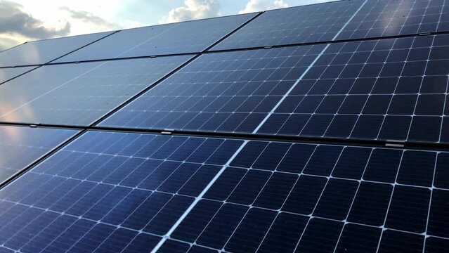 Timelapse of solar panel with scenic sunshine over cloudy sky and reflection on mono crystalline panel, green energy concept 