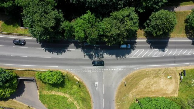 Straight down aerial drone footage of a main road t-junction from above showing the road in the town of Otley in Leeds West Yorkshire showing the road junction from above on a sunny day in the summer