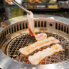 Hand Grilling meat pork on stove serve in restaurant. Japanese food and Korean BBQ traditional style