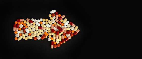Group of pills shaping arrow, top view studio shot group of pills shaping arrow. Isolated black...
