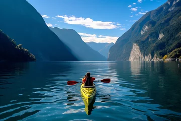 Foto op Canvas People kayaking on a calm lake, surrounded by towering mountains and clear blue skies Generative AI © forenna