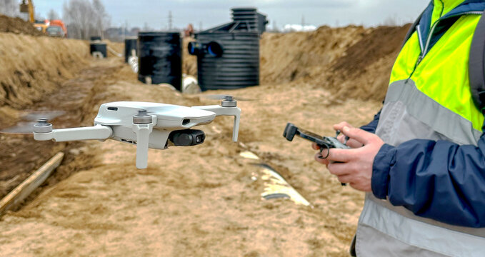 a surveyor with a quadcopter on a construction site