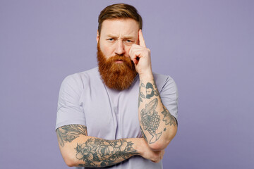 Young minded pensive redhead bearded man he wear violet t-shirt casual clothes looking camea prop...