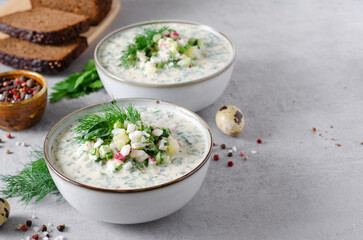 Cold Okroshka Soup with Eggs, Vegetables, Meat, Herbs and Kefir on a Bright Background, Summer Soup