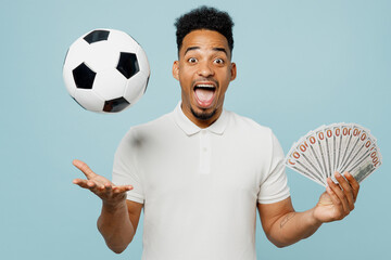 Young surprised happy man fan in basic t-shirt cheer up support football sport team hold fan of...