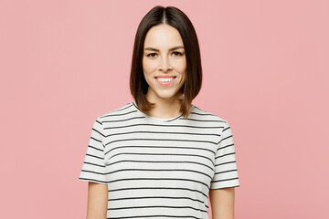 Obraz premium Young smiling happy satisfied fun cheerful caucasian woman she wears casual clothes t-shirt looking camera isolated on plain pastel light pink color wall background studio portrait. Lifestyle concept.