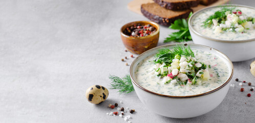 Cold Okroshka Soup with Eggs, Vegetables, Meat, Herbs and Kefir on a Bright Background, Summer Soup