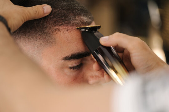 Close-up of barber use trimer for making modern hair cut. Barber shop