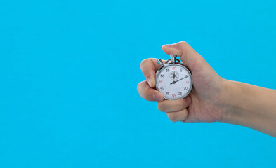 People hand holding stopwatch on blue background