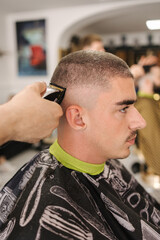 Side view of male client sitting in barber shop. Hair cut in salon 