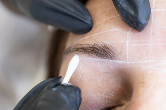 Professional eyebrow mapping in action: a close-up view of a woman prepping for permanent makeup