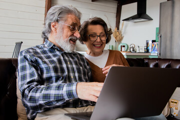 Mature pensioners man and woman using technology - isolation and quarantine lifestyle