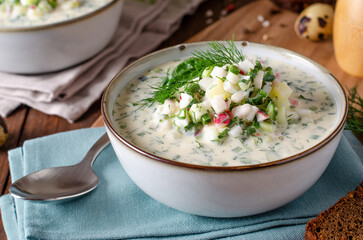 Cold Okroshka Soup with Eggs, Vegetables, Meat, Herbs and Kefir on a Wooden Background, Summer Soup