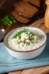 Cold Okroshka Soup with Eggs, Vegetables, Meat, Herbs and Kefir on a Wooden Background, Summer Soup