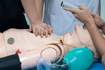 Anesthesiologist performing an orotracheal intubation on a simulation, Medical manipulation. mannequin dummy during medical training to control of the airway.